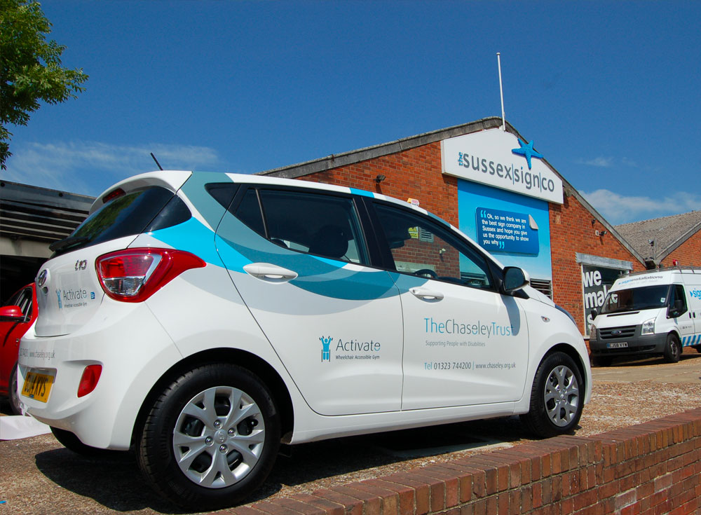 small white toyota 4 door car with digitally printed signage advertising The Chaseley Trust