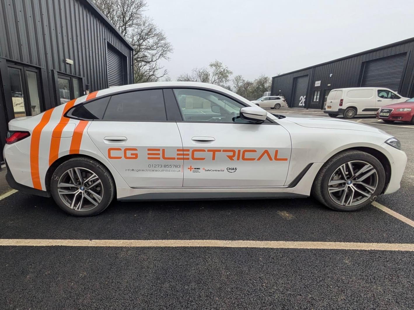White BMW i4 electric car with orange cut vinyl signwriting and racing stripes for CG Electrical contractors based in Sussex