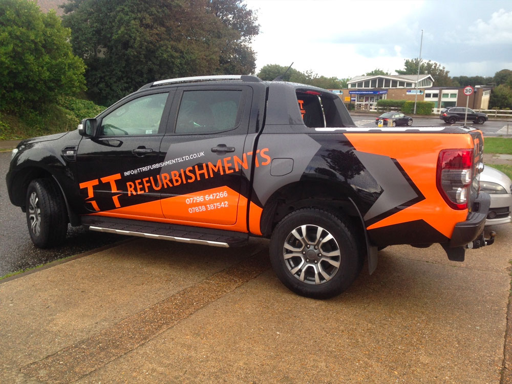 white, orange and grey vinyls applied to twin can truck promoting TT Refurbishments