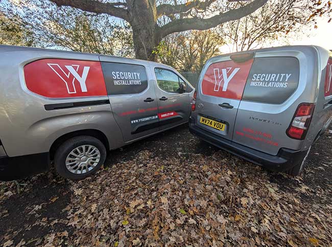YY Security signwritten van fleet showing printed vinyl decals applied to van recess panels zoomed in shot